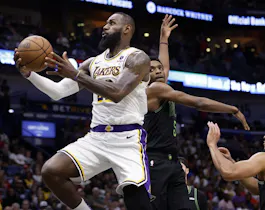 LeBron James of the Los Angeles Lakers goes up for a shot ahead of Herbert Jones and CJ McCollum of the New Orleans Pelicans at Smoothie King Center. We're looking at the Lakers star in our LeBron James NBA player props.