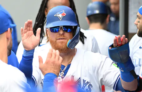 Toronto Blue Jays designated hitter Justin Turner is greeted by teammates in the dugout after scoring against the Baltimore Orioles in the sixth inning at Rogers Centre as we look at our Blue Jays vs. Brewers player props.