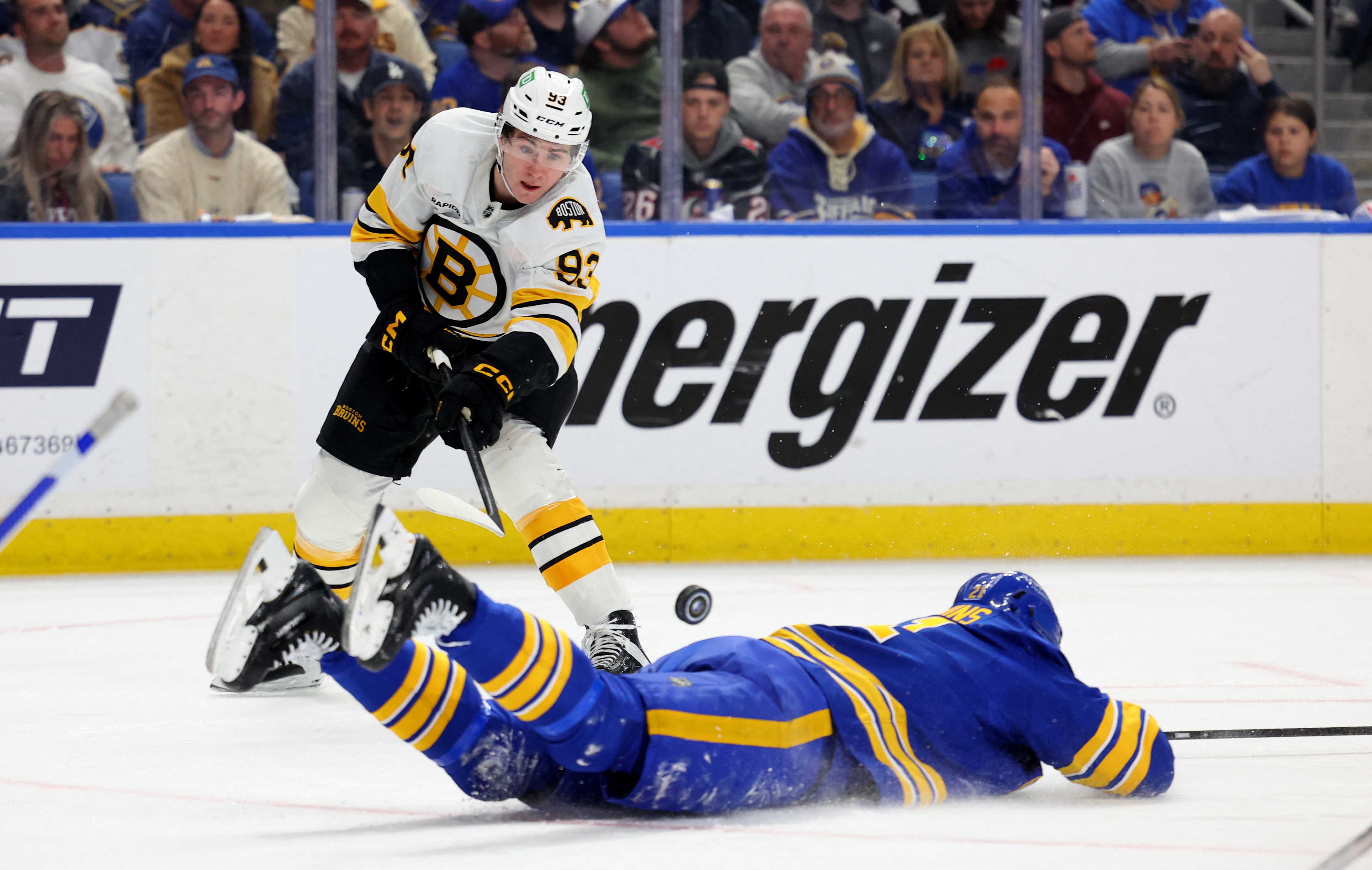 Buffalo Sabres defenseman Conor Timmins tries to block a pass by Boston Bruins center Fraser Minten as we offer our best Sabres vs. Bruins prediction.