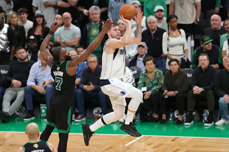 Dallas Mavericks guard Luka Doncic (77) shoots the ball against Boston Celtics guard Jaylen Brown (7), as we examine the NBA Finals odds and betting trends on the Mavericks' chances to erase an 0-2 series deficit in the NBA Finals.