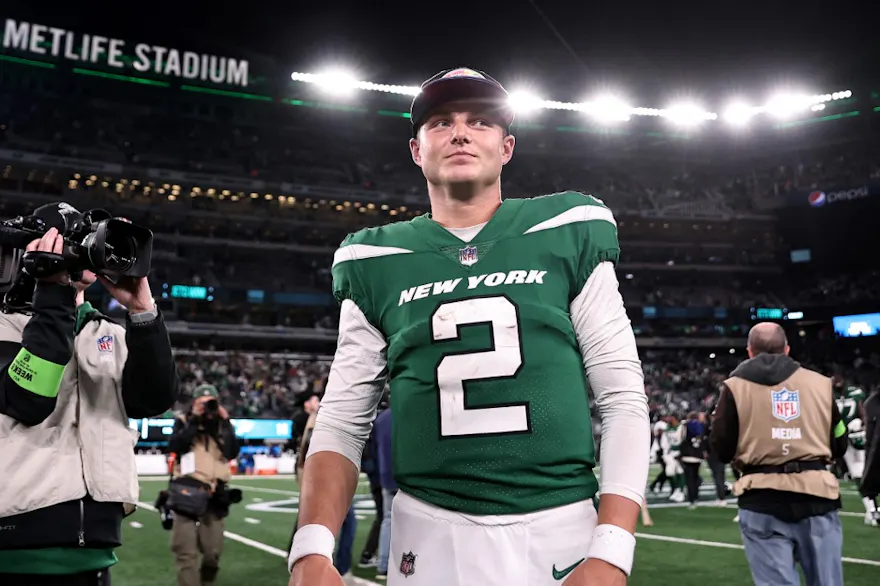 Zach Wilson of the New York Jets walks on the field after a win over the Philadelphia Eagles, and we offer our top Zach Wilson player prop predictions for Chargers vs. Jets based on the best NFL odds.