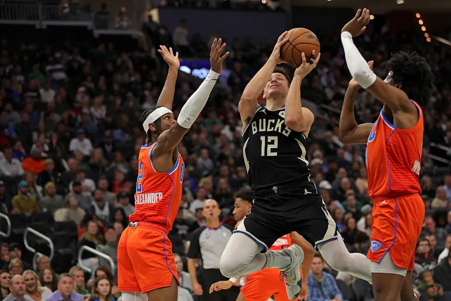 Grayson Allen of the Milwaukee Bucks is defended by Shai Gilgeous-Alexander and Jalen Williams of the Oklahoma City Thunder during the first half of a game at Fiserv Forum on November 05, 2022 in Milwaukee, Wisconsin.