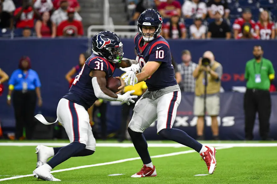 Davis Mills hands the ball off to Dameon Pierce of the Houston Texans in the first quarter during a preseason game against the San Francisco 49ers at NRG Stadium on August 25, 2022 in Houston, Texas.