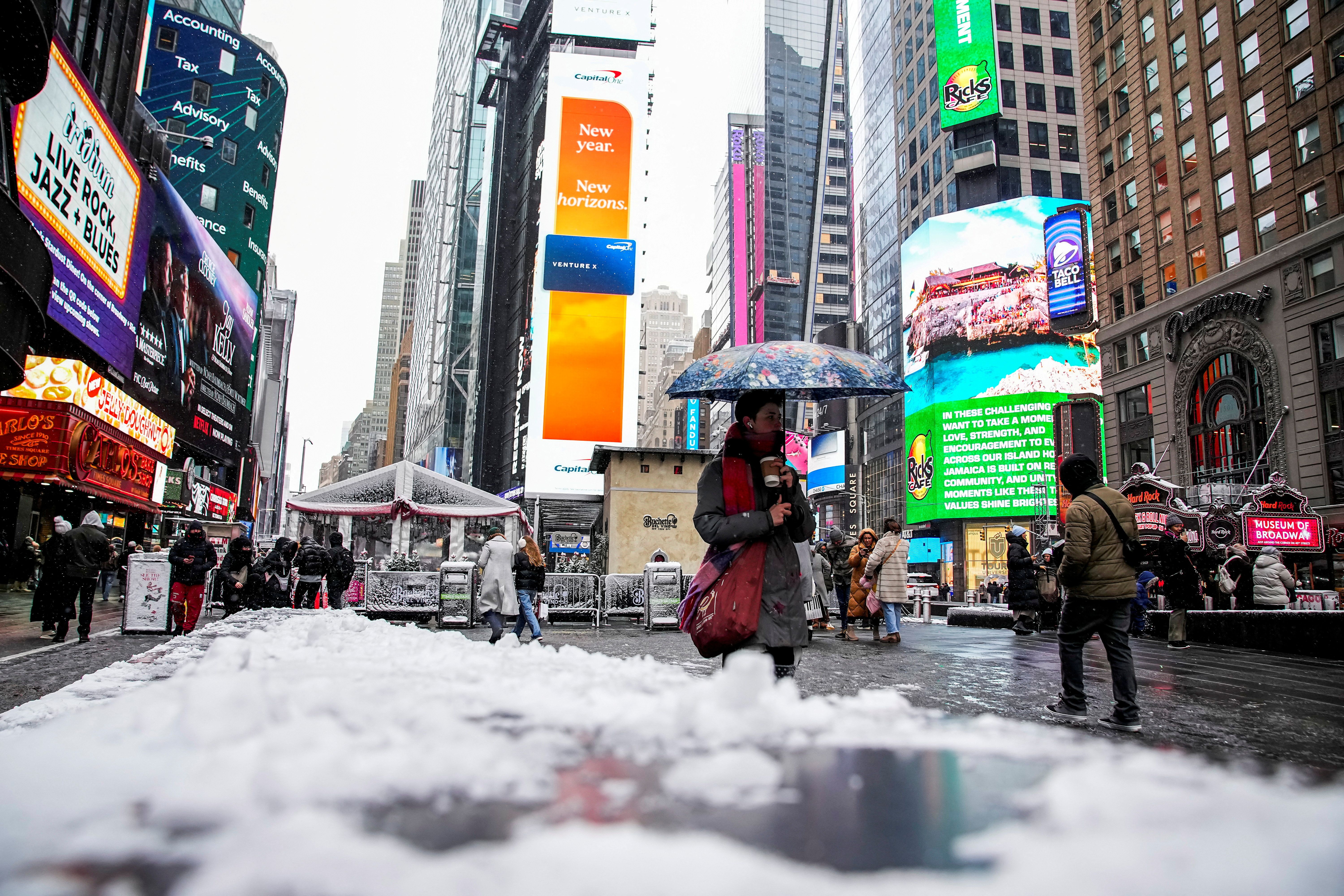 People make their way during a snowfall at Times Square as we look at the snow in New York City odds