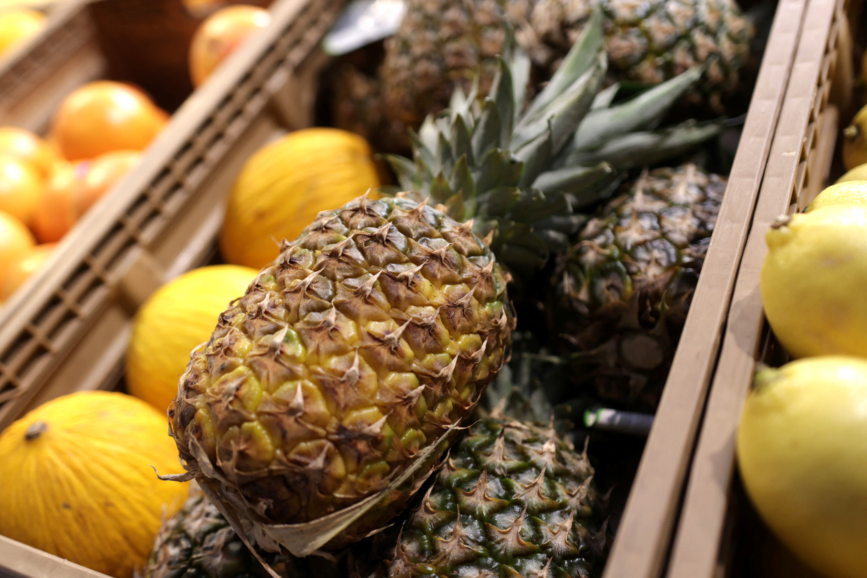 Pineapples are displayed in a supermarket.