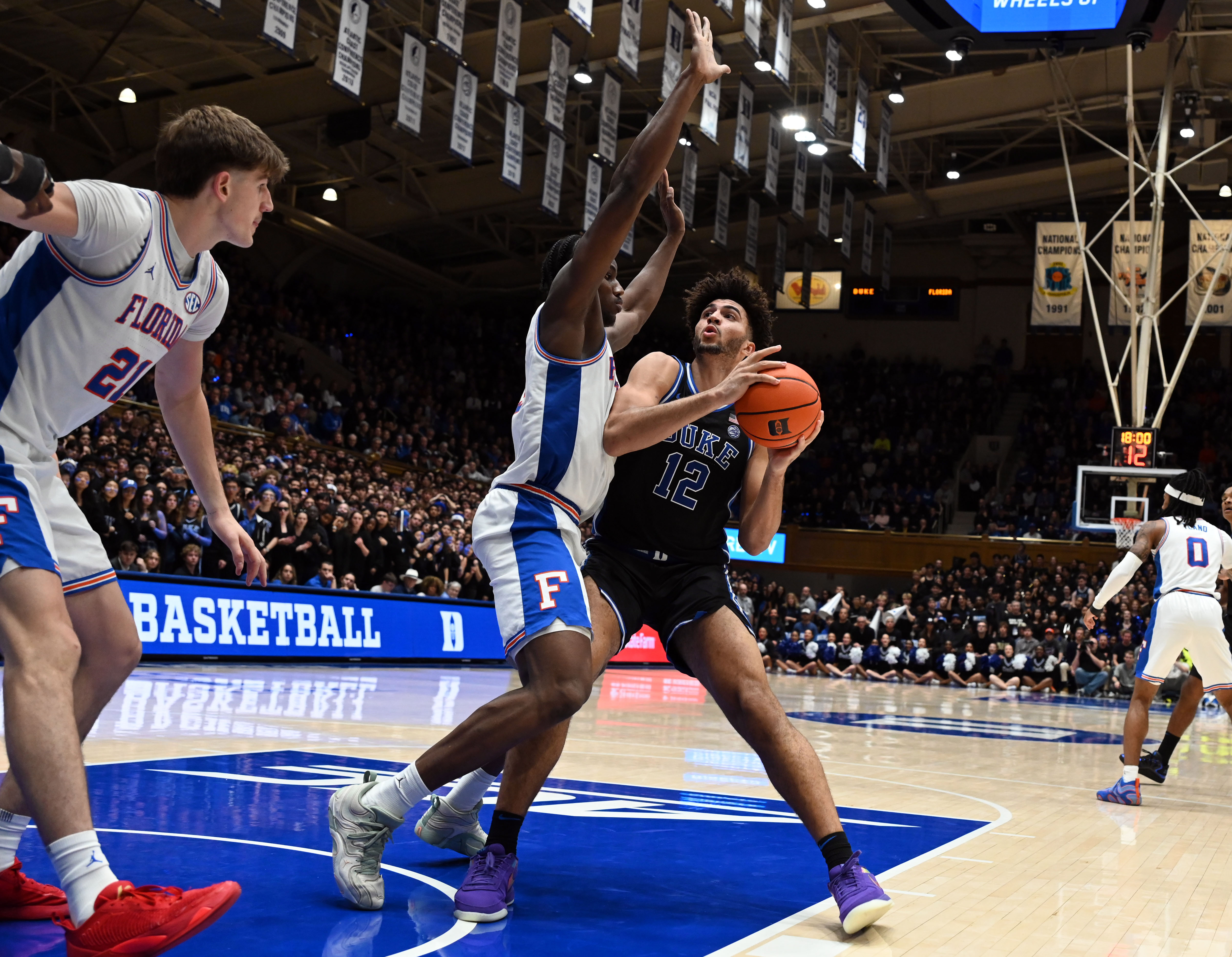 Duke Blue Devils forward Cameron Boozer (12) looks to shoot as Florida Gators center Rueben Chinyelu (9) defends. Duke and Florida are among the March Madness odds favorites.
