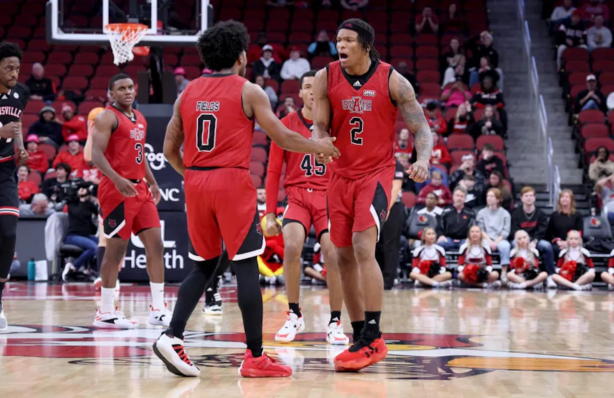 Caleb Fields and Derrian Ford of the Arkansas State Red Wolves celebrate in the 75-63 win against the Louisville Cardinals as we look at our Arkansas State-James Madison predictions.