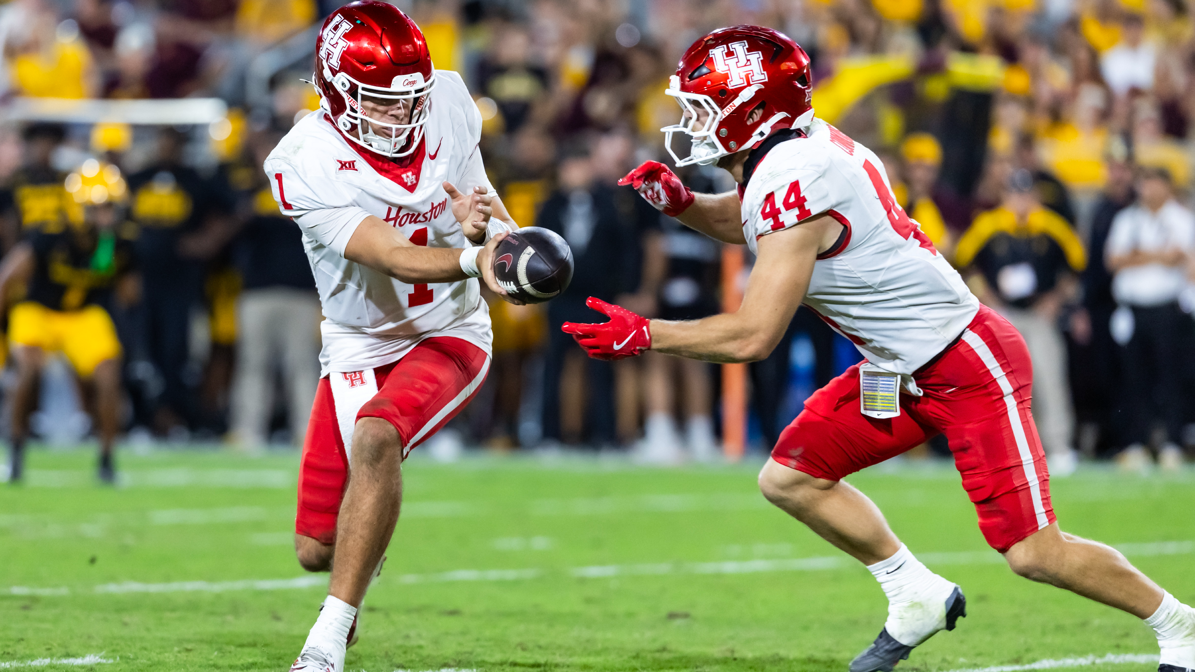Houston Cougars quarterback Conner Weigman hands off the ball to running back Dean Connors as we make our Oregon State vs. Houston early predictions