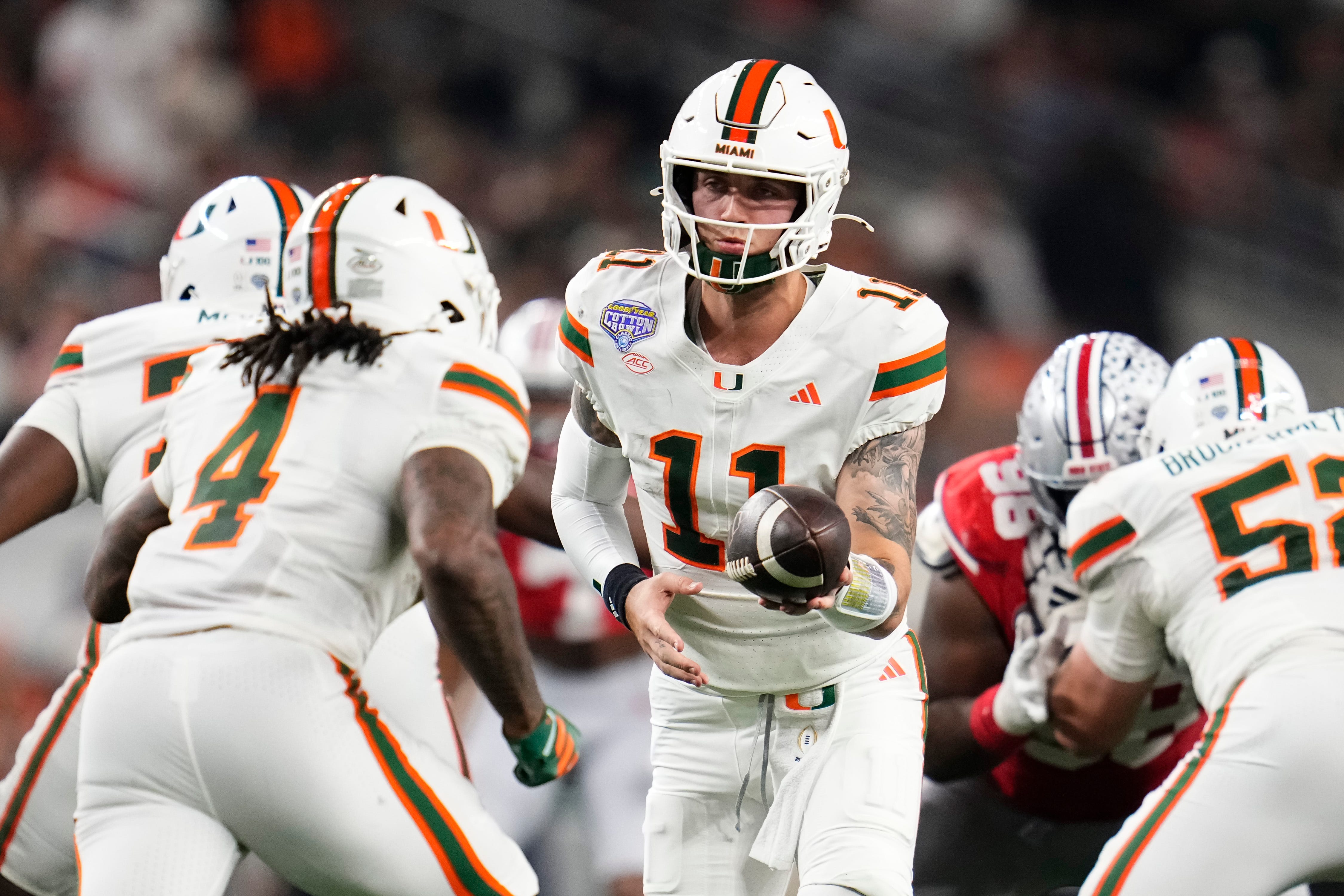Miami quarterback Carson Beck (11) hands off to running back Mark Fletcher Jr. (4) as we offer our Miami vs. Ole Miss same-game parlay for the Fiesta Bowl.