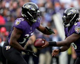 Quarterback Lamar Jackson #8 hands the ball off to running back Gus Edwards #35 of the Baltimore Ravens against the Cleveland Browns at M&T Bank Stadium on Oct. 23.