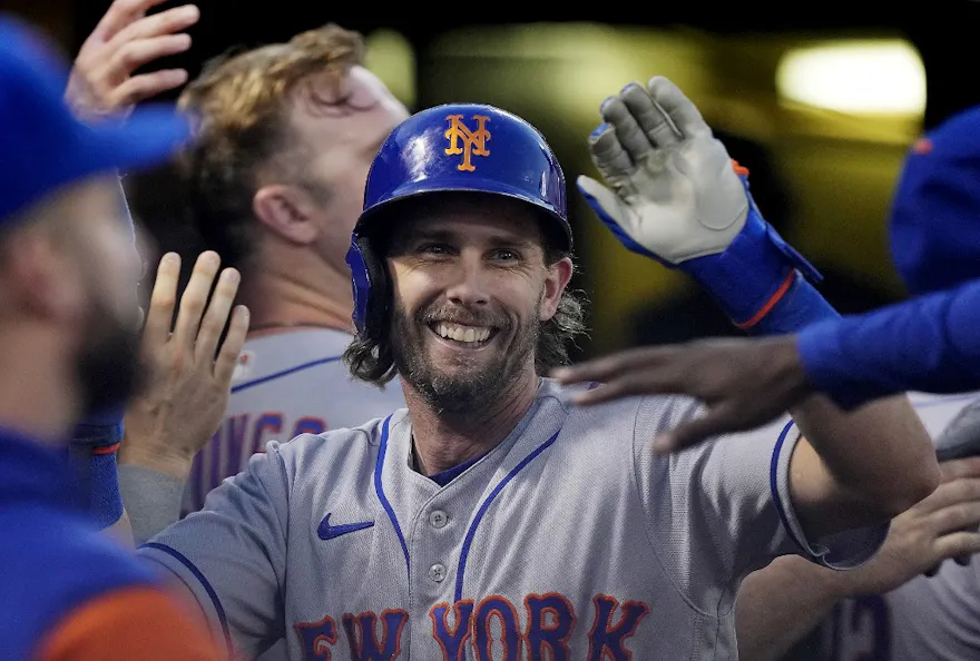Jeff McNeil of the New York Mets is congratulated by teammates in the dugout after scoring against the Oakland Athletics in the top of the second inning.