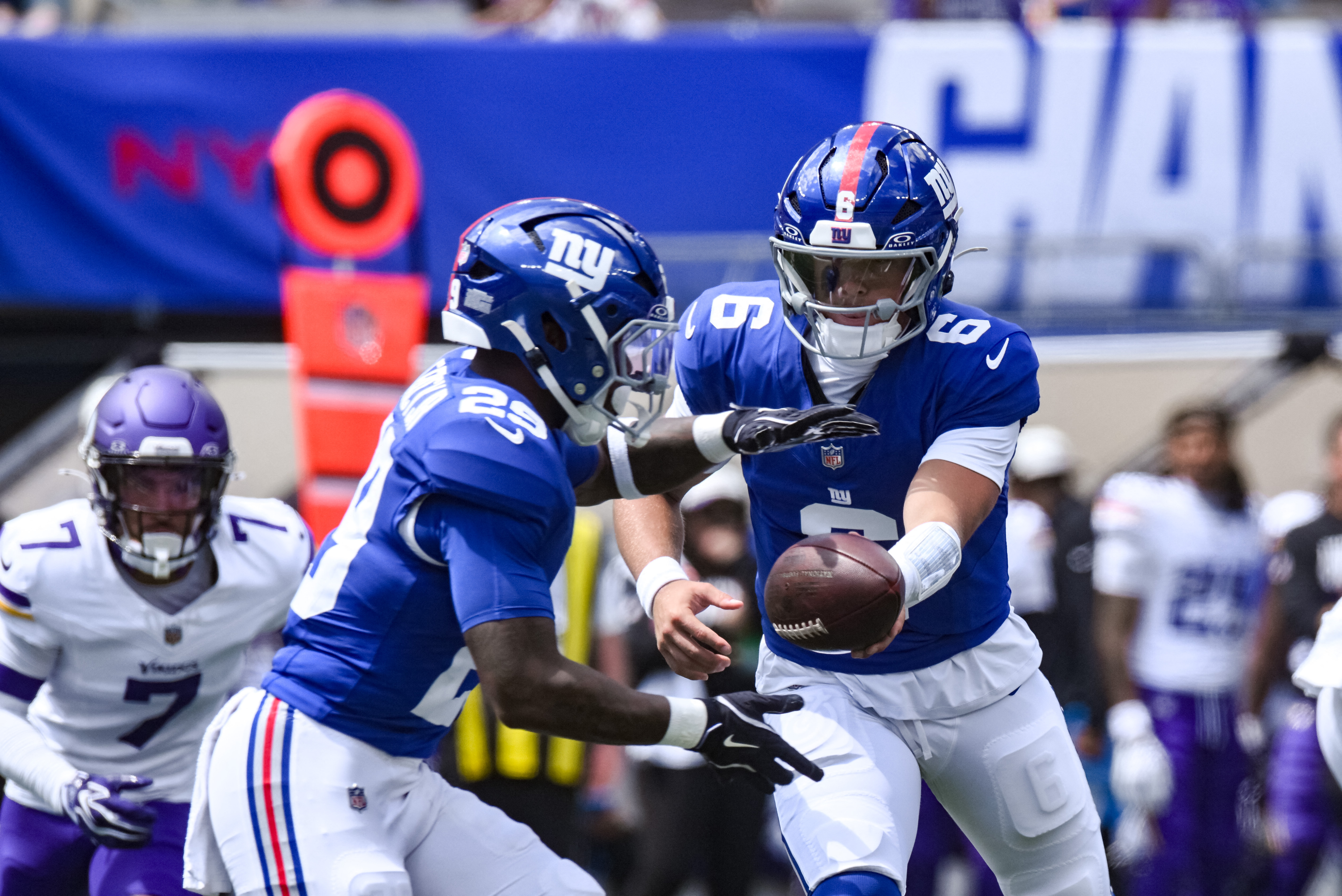New York Giants quarterback Jaxson Dart hands the ball off to running back Tyrone Tracy Jr. as we make our best Giants vs. Dolphins prediction.