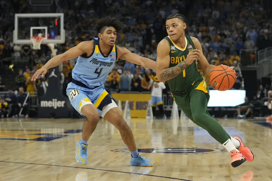 Keyonte George of the Baylor Bears dribbles the ball against Stevie Mitchell of the Marquette Golden Eagles during the first half at Fiserv Forum.