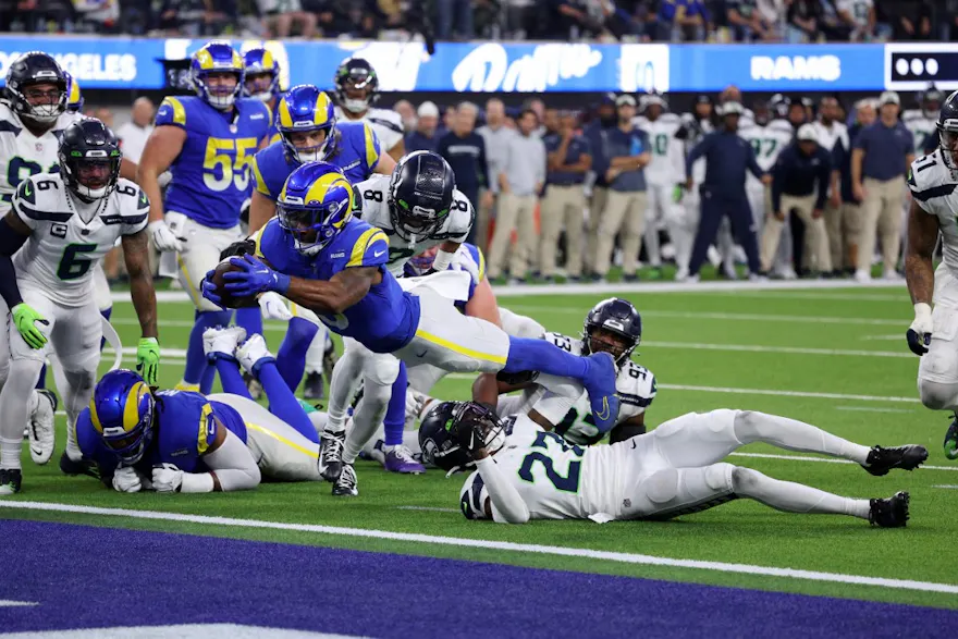 Cam Akers of the Los Angeles Rams dives over Tariq Woolen of the Seattle Seahawks to score a touchdown in the fourth quarter of the game at SoFi Stadium on December 04, 2022 in Inglewood, California.