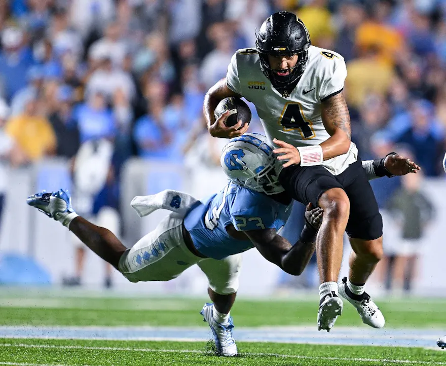 Power Echols (L) #23 of the North Carolina Tar Heels tackles Joey Aguilar #4 of the Appalachian State Mountaineers as we make our Appalachian State vs. Troy Sun Belt Championship predictions and picks.
