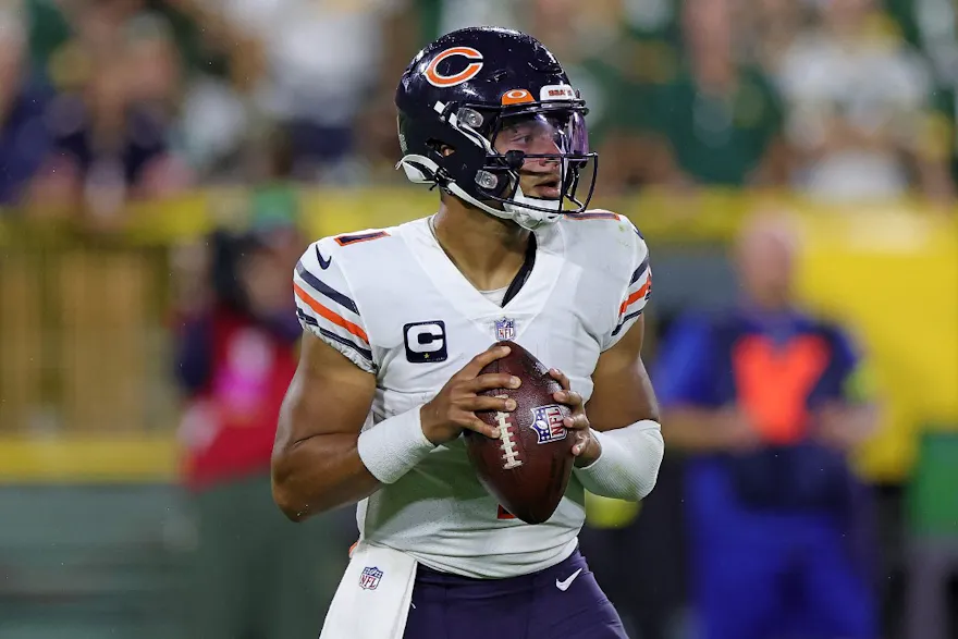 Justin Fields of the Chicago Bears drops back to pass during a game against the Green Bay Packers, and we offer new U.S. bettors our exclusive Caesars promo code.