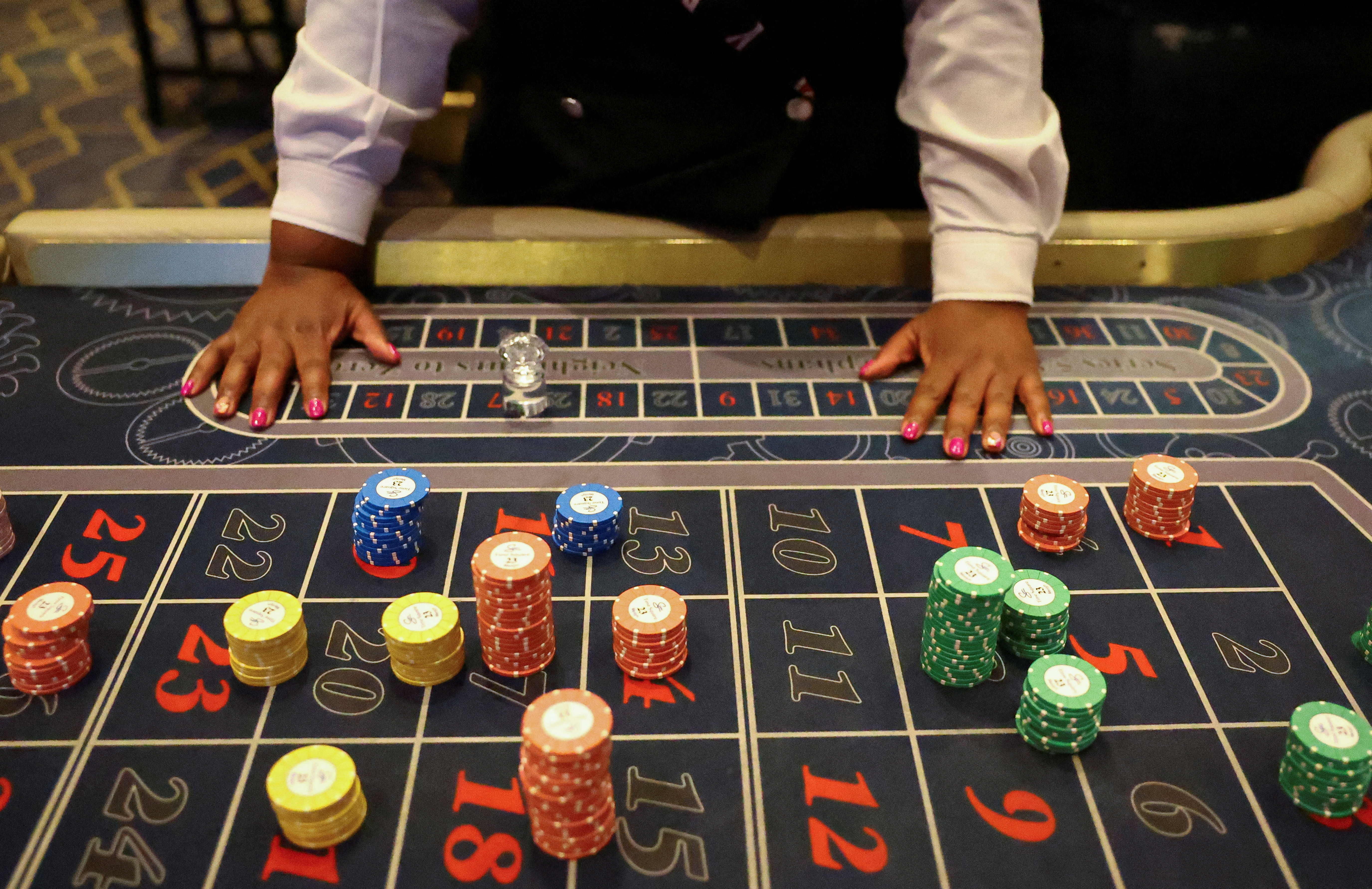 A casino employee stands near stacks of chips on a roulette table as we look at Tennessee taking steps to ban sweepstakes casinos.