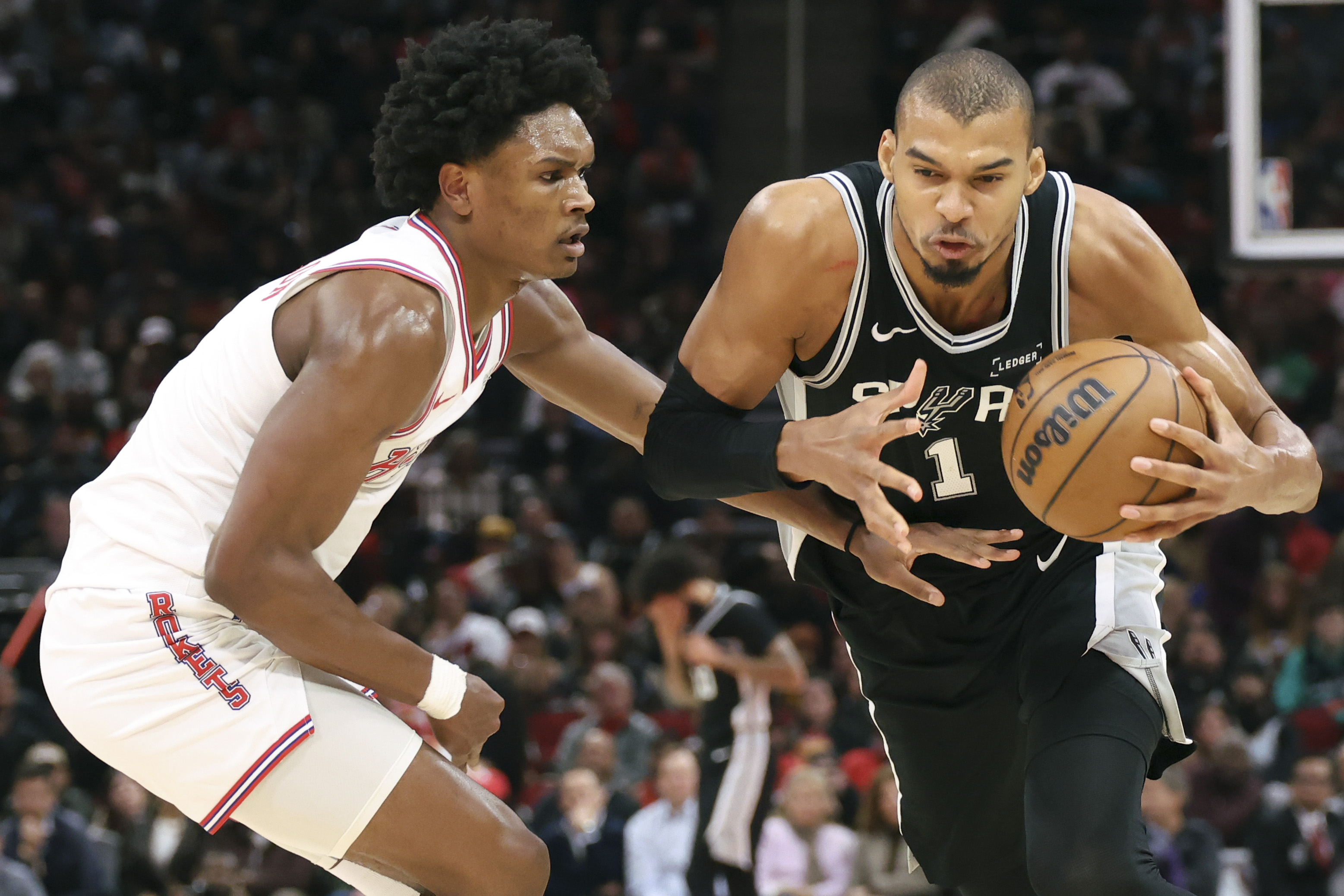 San Antonio Spurs center Victor Wembanyama (1) controls the ball against Houston Rockets guard Amen Thompson (1) as we offer our Rockets vs. Spurs prediction.