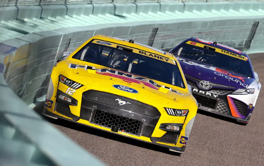 Ryan Blaney, driver of the #12 Menards/Pennzoil Ford, and Denny Hamlin, driver of the #11 FedEx Ground Toyota, race during the NASCAR Cup Series Dixie Vodka 400 at Homestead-Miami Speedway on Oct. 23, 2022 in Homestead, Florida.