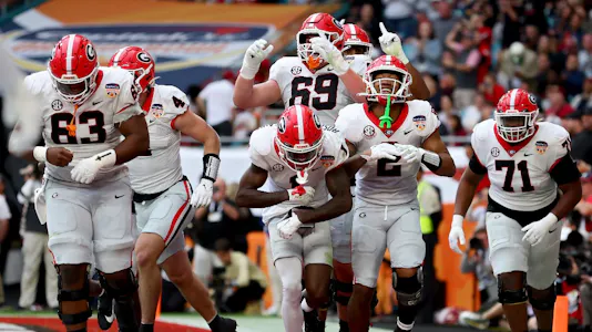 Kendall Milton of the Georgia Bulldogs celebrates with teammates after scoring a touchdown against the Florida State Seminoles during the Capital One Orange Bowl. Georgia leads the way for the College Football Projected Win Totals. 