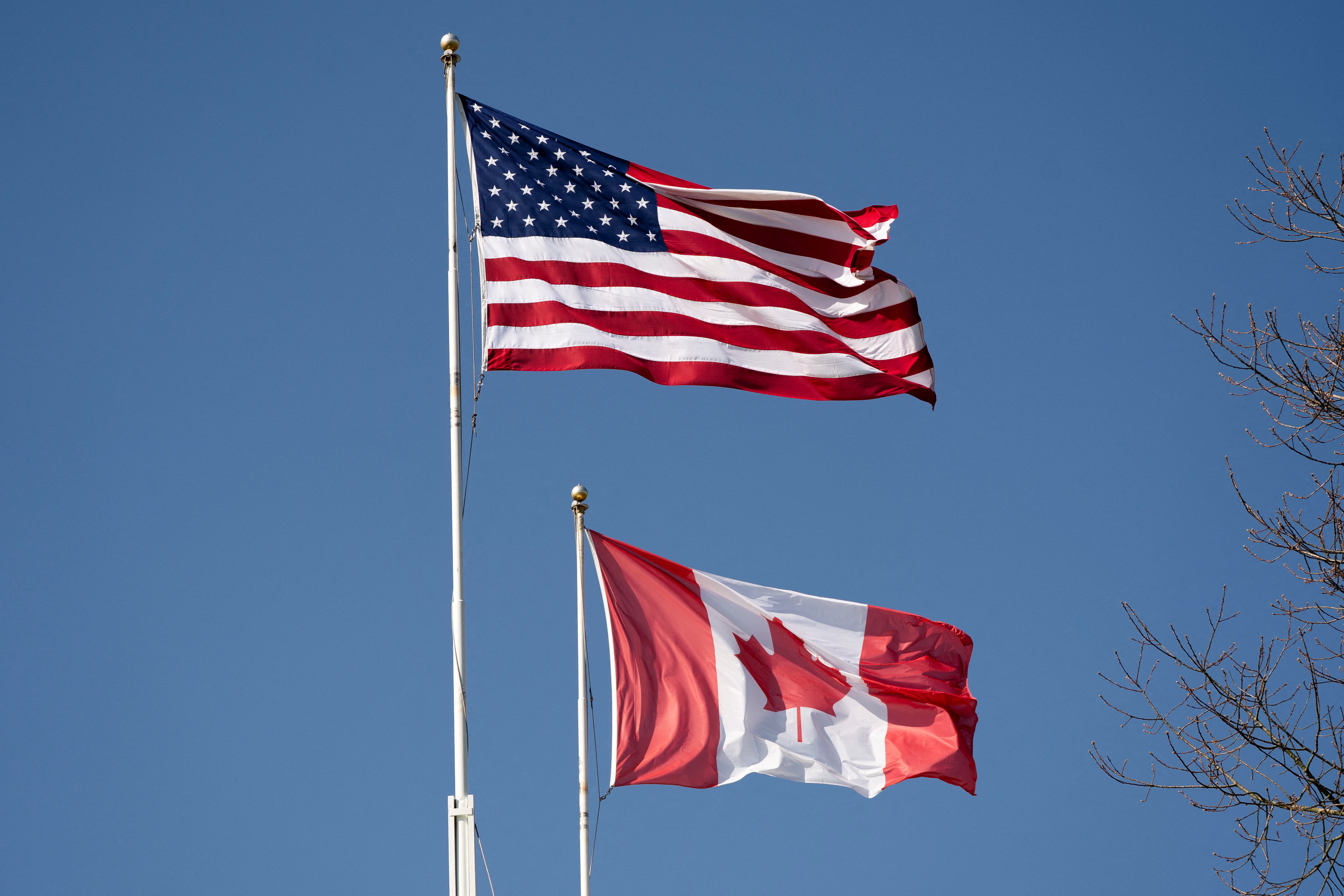 The US and Canadian flags fly above the Peace Arch as we look at the state of prediction markets on each side of the border.