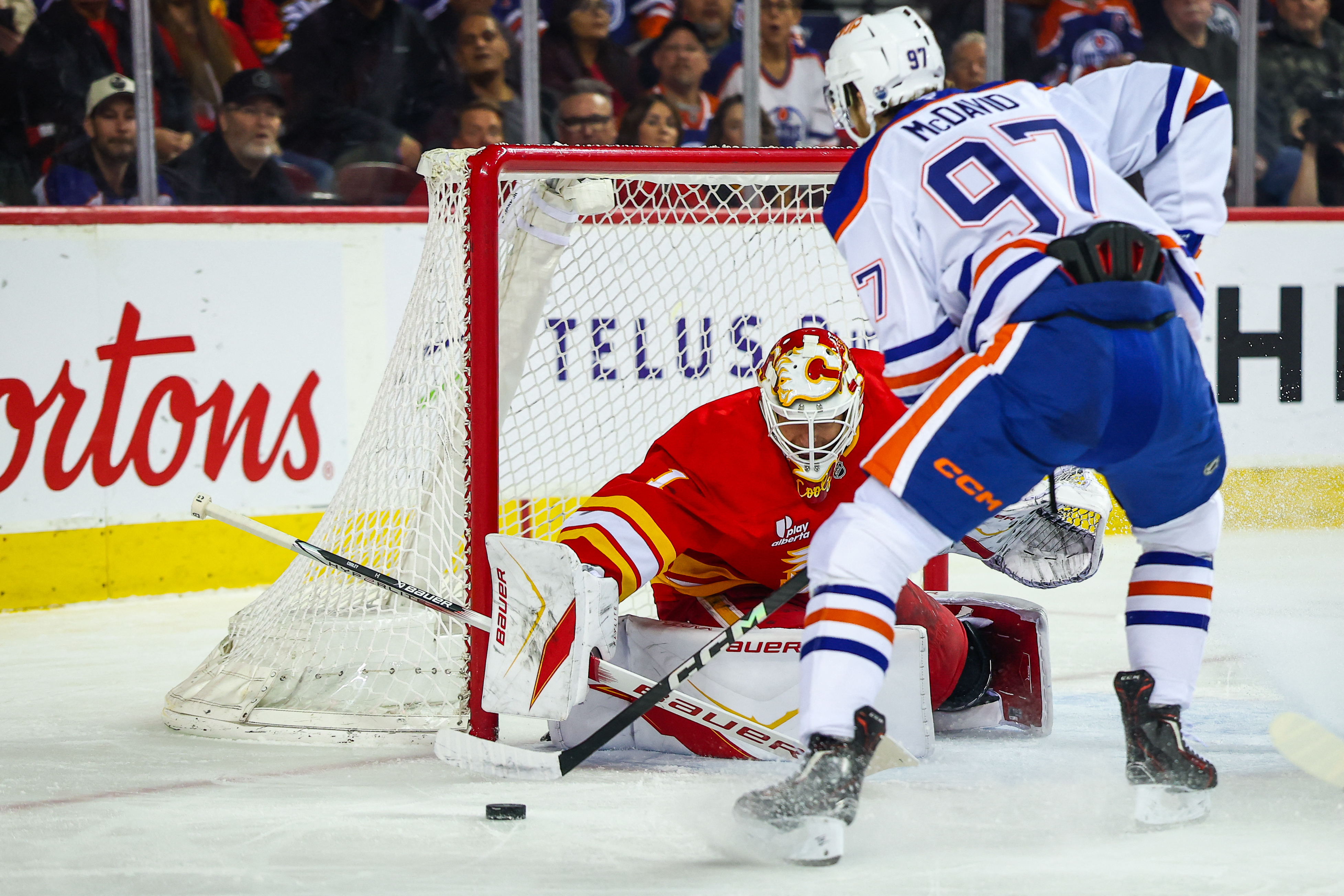 Calgary Flames goaltender Devin Cooley (1) makes a save against Edmonton Oilers center Connor McDavid (97) as we offer our NHL predictions today.