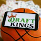 DraftKings logo displayed on a mobile phone, a basketball, and playing cards are seen in this illustration photo.