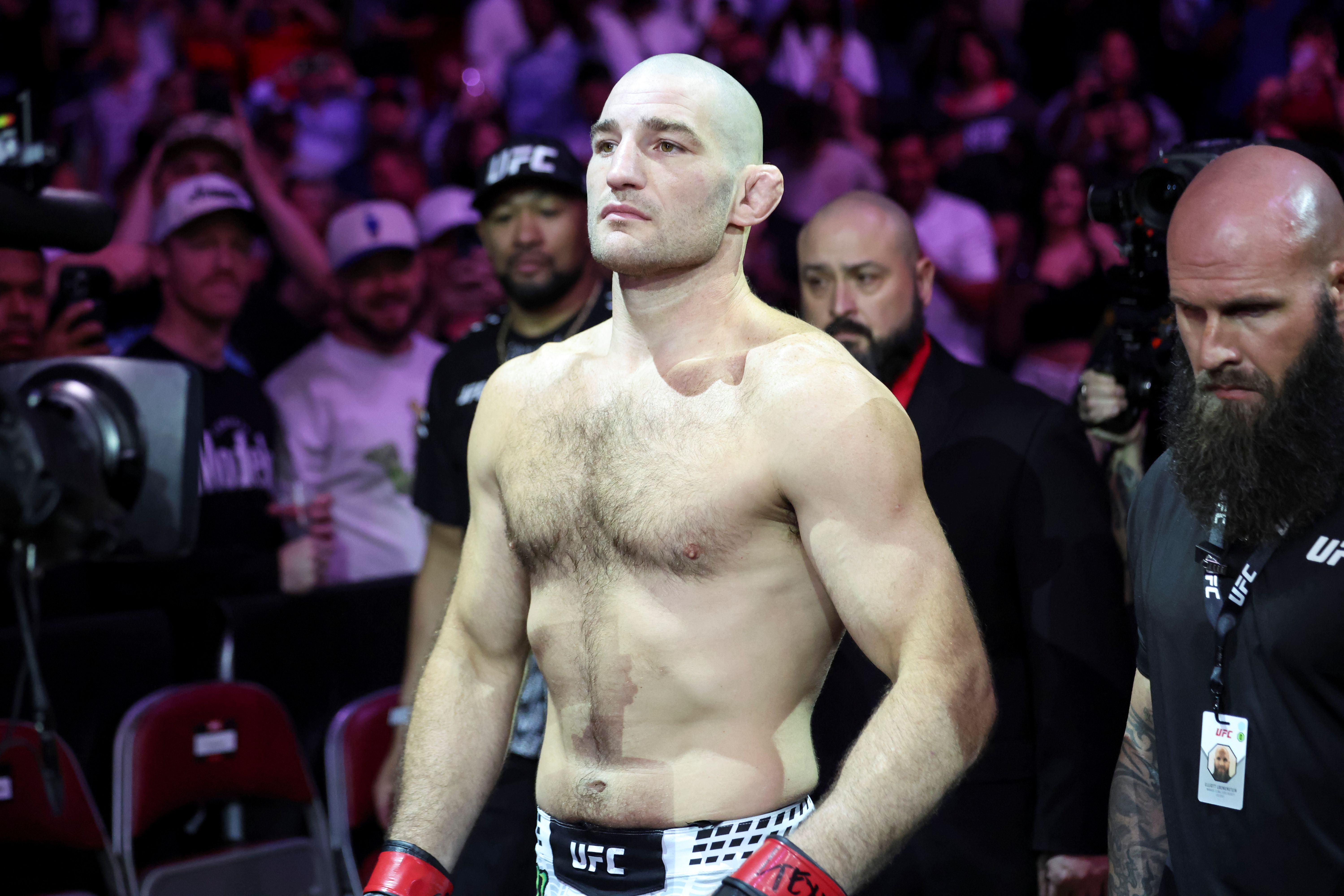 Sean Strickland (red gloves), seen here during a fight, is featured in our UFC 328 odds and betting insights.