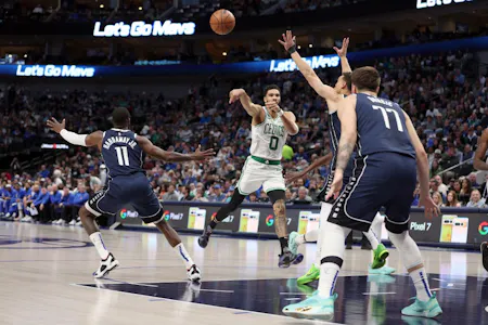 Jayson Tatum of the Boston Celtics passes the ball against Dwight Powell of the Dallas Mavericks and Tim Hardaway Jr. of the Dallas Mavericksin at American Airlines Center. We're backing Tatum in our Mavericks vs. Celtics Player Props.
