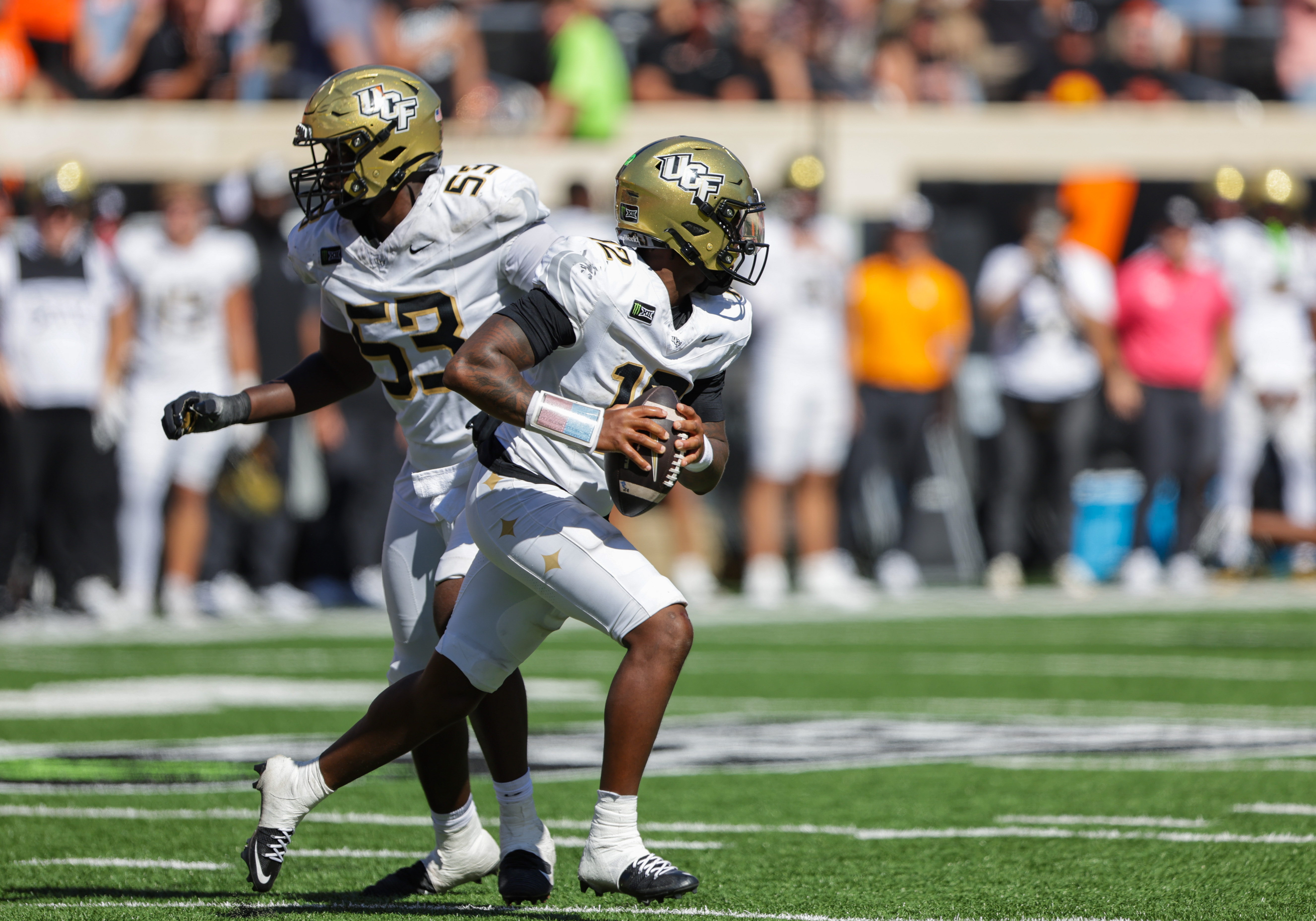 UCF Knights quarterback Keyone Jenkins (12) rolls out looking for an open receiver as he is featured in our BYU vs. UCF prediction.