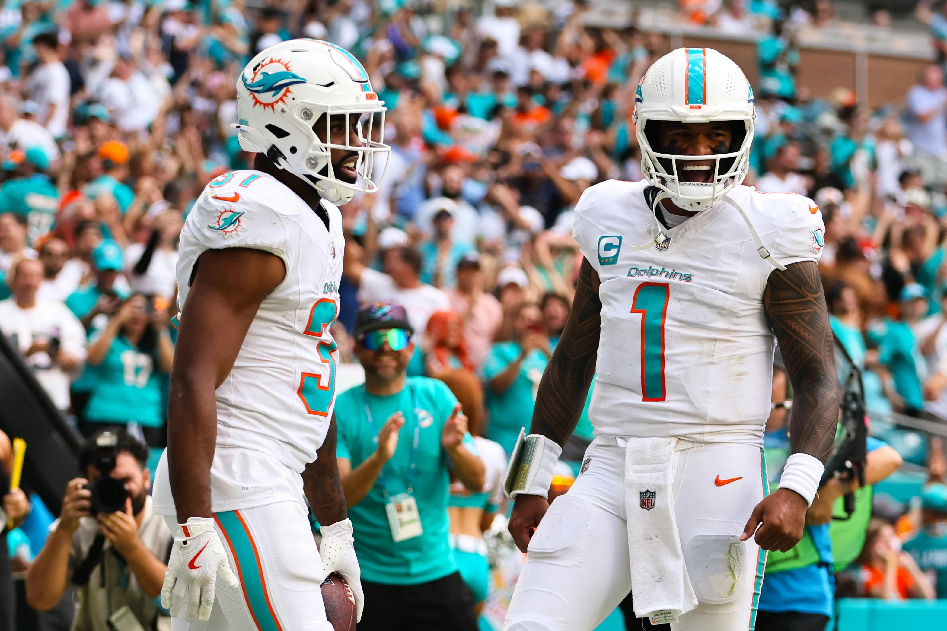 Miami Dolphins running back Raheem Mostert and quarterback Tua Tagovailoa celebrate as we offer our NFL Week 10 predictions.