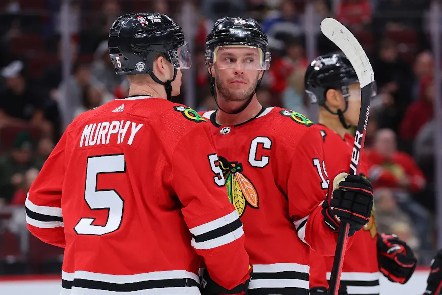 Connor Murphy #5 and Jonathan Toews #19 of the Chicago Blackhawks talk against the St. Louis Blues during the third period of a preseason game at United Center on September 27, 2022 in Chicago, Illinois.