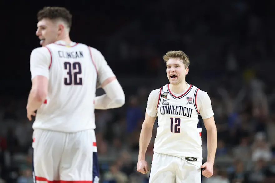 Cam Spencer #12 and Donovan Clingan #32 of the Connecticut Huskies celebrate as we offer our best last-minute national championship game picks for Purdue vs. UConn ahead of Monday's NCAA Tournament final.