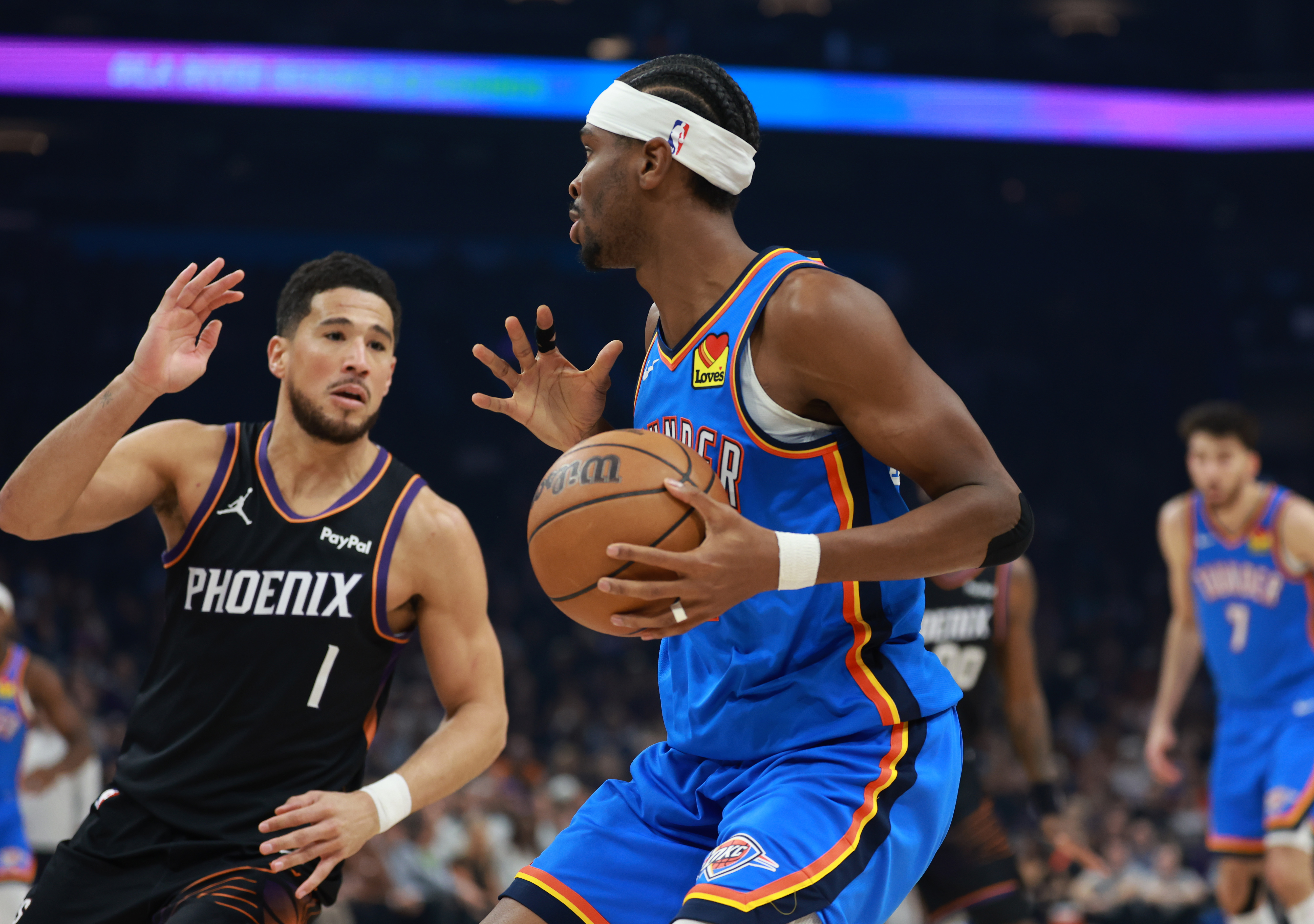 Oklahoma City Thunder guard Shai Gilgeous-Alexander (2) against Phoenix Suns guard Devin Booker (1) in the first half at Mortgage Matchup Center.