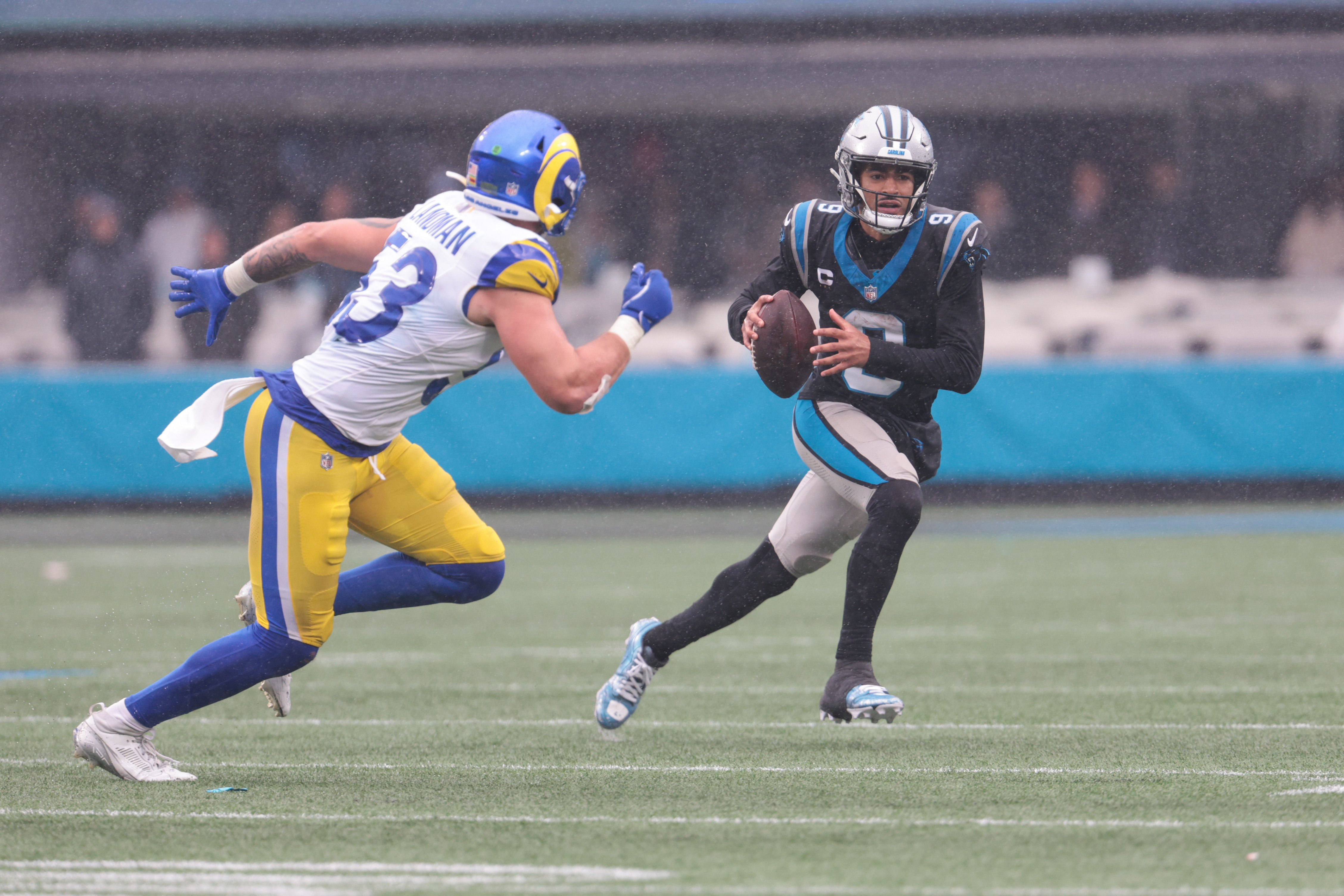 Panthers QB Bryce Young looks to pass as Rams linebacker Nate Landman defends, and we offer our best Panthers vs. Rams early predictions