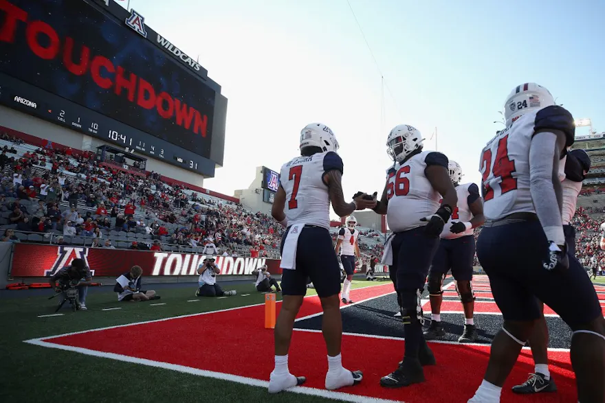 Quarterback Jayden de Laura of the Arizona Wildcats celebrates with Josh Donovan after scoring an 11-yard rushing touchdown against the Washington State Cougars.