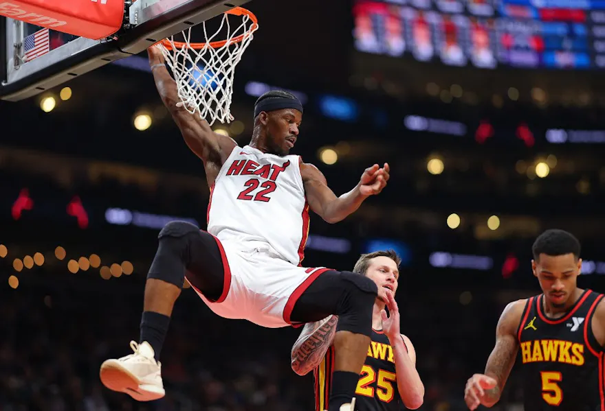 Jimmy Butler of the Miami Heat dunks against Garrison Mathews and Dejounte Murray of the Atlanta Hawks. We're backing Butler in our Raptors vs. Heat player props. 