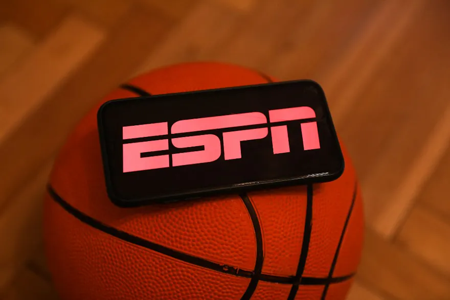 ESPN logo displayed on a phone screen and a basketball are seen in this illustration photo taken in Krakow, Poland as we look at ESPN Bet.