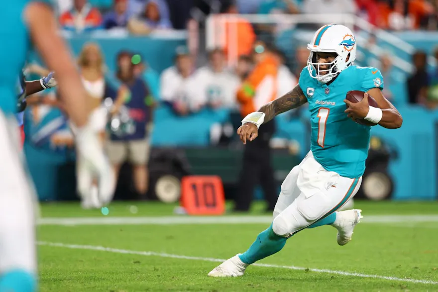 Tua Tagovailoa of the Miami Dolphins runs the ball ahead of our Week 15 NFL predictions for Jets vs. Dolphins 