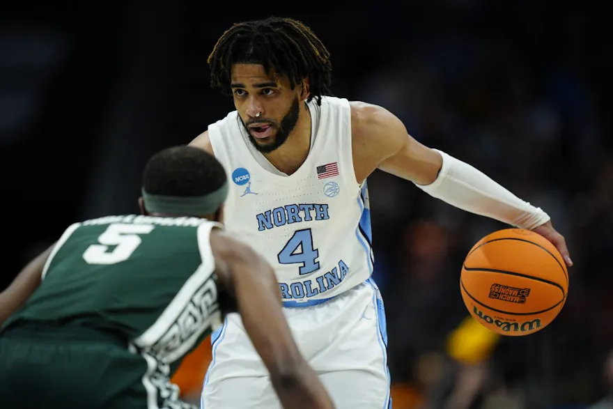 RJ Davis of the North Carolina Tar Heels handles the ball against Tre Holloman of the Michigan State Spartans during the second round of the NCAA Men's Basketball Tournament. We're back North Carolina and Davis in our Sweet 16 expert picks.