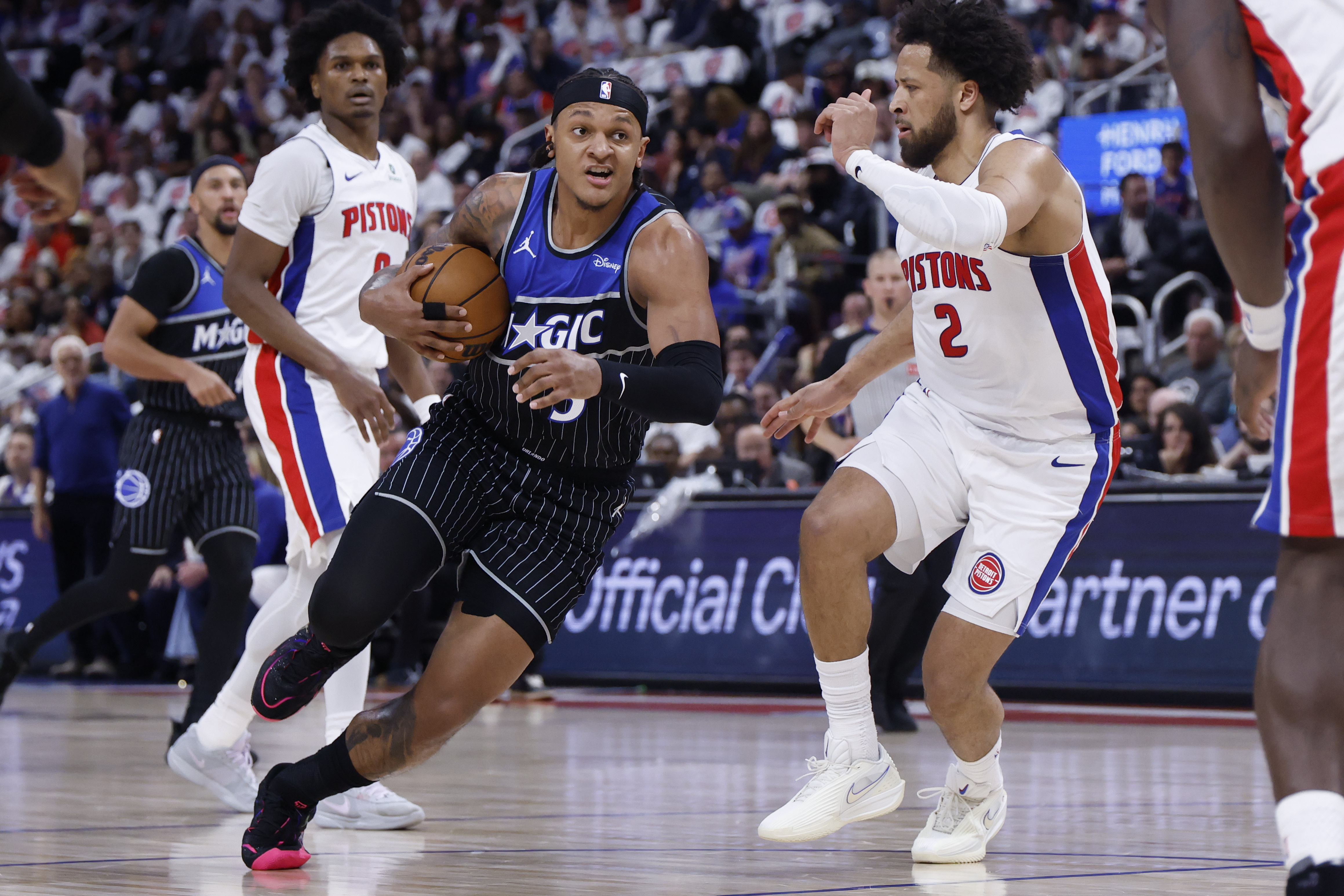 Orlando Magic forward Paolo Banchero (5) defended by Detroit Pistons guard Cade Cunningham (2) as we provide our Pistons vs. Magic Game 3 player props.