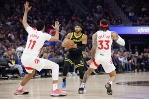 Moses Moody (4) of the Golden State Warriors looks to shoot the ball against Jontay Porter (11) and Gary Trent Jr. (33) of the Toronto Raptors, as we examine the partnership between IC360 and Radar to offer geolocation services in sports betting.
