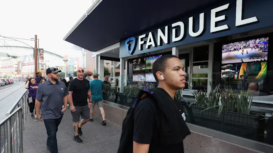 Fans walk past a Fanduel sports betting location as we look at FanDuel's takeover of GamBetDC