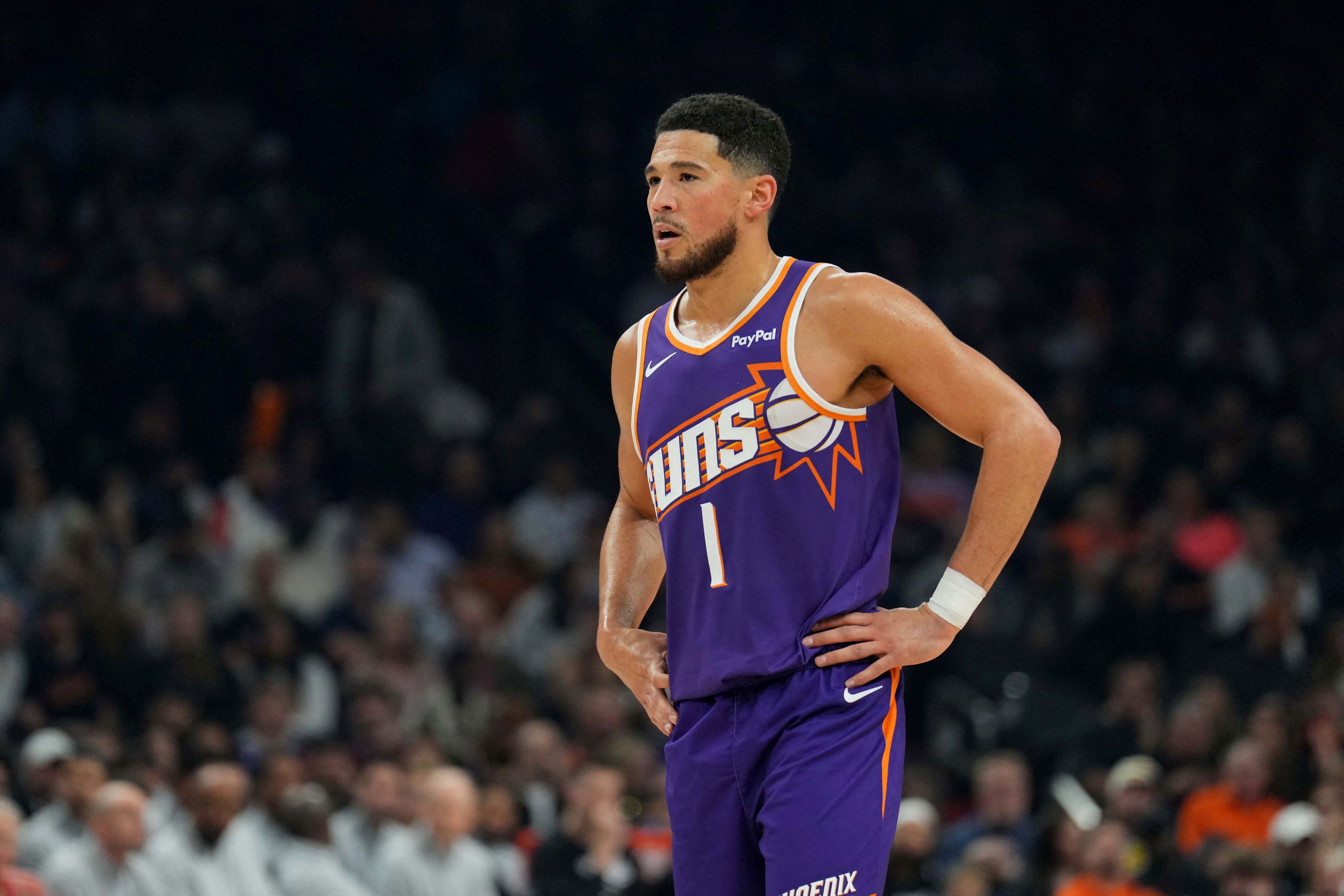 Phoenix Suns guard Devin Booker (1), seen here looking on during a game, is featured in our NBA player props tonight.