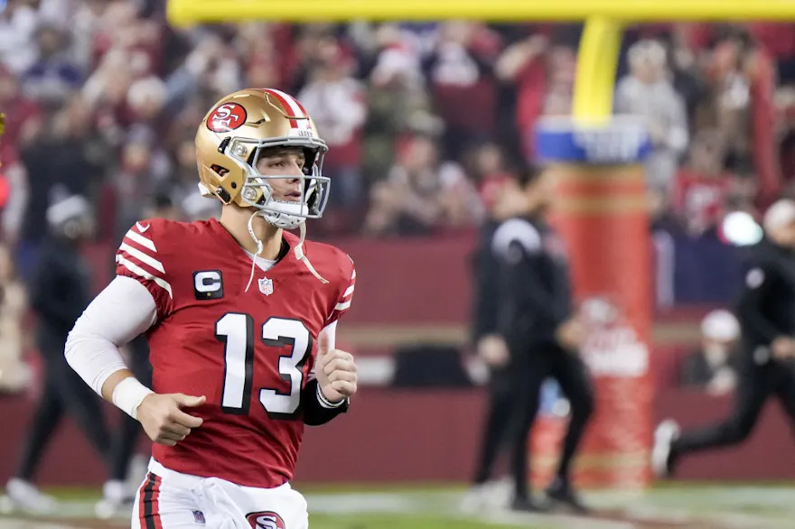 Brock Purdy #13 of the San Francisco 49ers runs onto the field as we make our Brock Purdy NFL player props picks and predictions for Sunday's NFC Championship against the Detroit Lions.