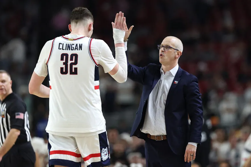 Donovan Clingan and head coach Dan Hurley of the UConn Huskies celebrate against the Alabama Crimson Tide in the NCAA Men's Basketball Tournament. We're breaking down the Huskies in our national championship odds, injuries & last minute news for bettors.