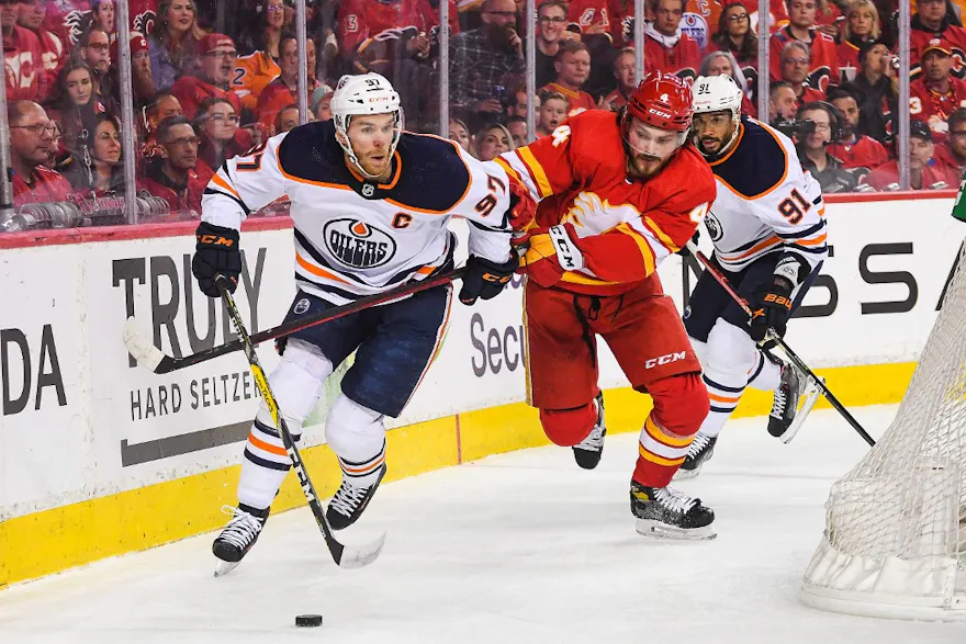 Connor McDavid of the Edmonton Oilers carries the puck against Rasmus Andersson of the Calgary Flames during the first period of Game 2 of the Second Round of the 2022 Stanley Cup Playoffs at Scotiabank Saddledome on May 20, 2022 in Calgary, Alberta, Cana