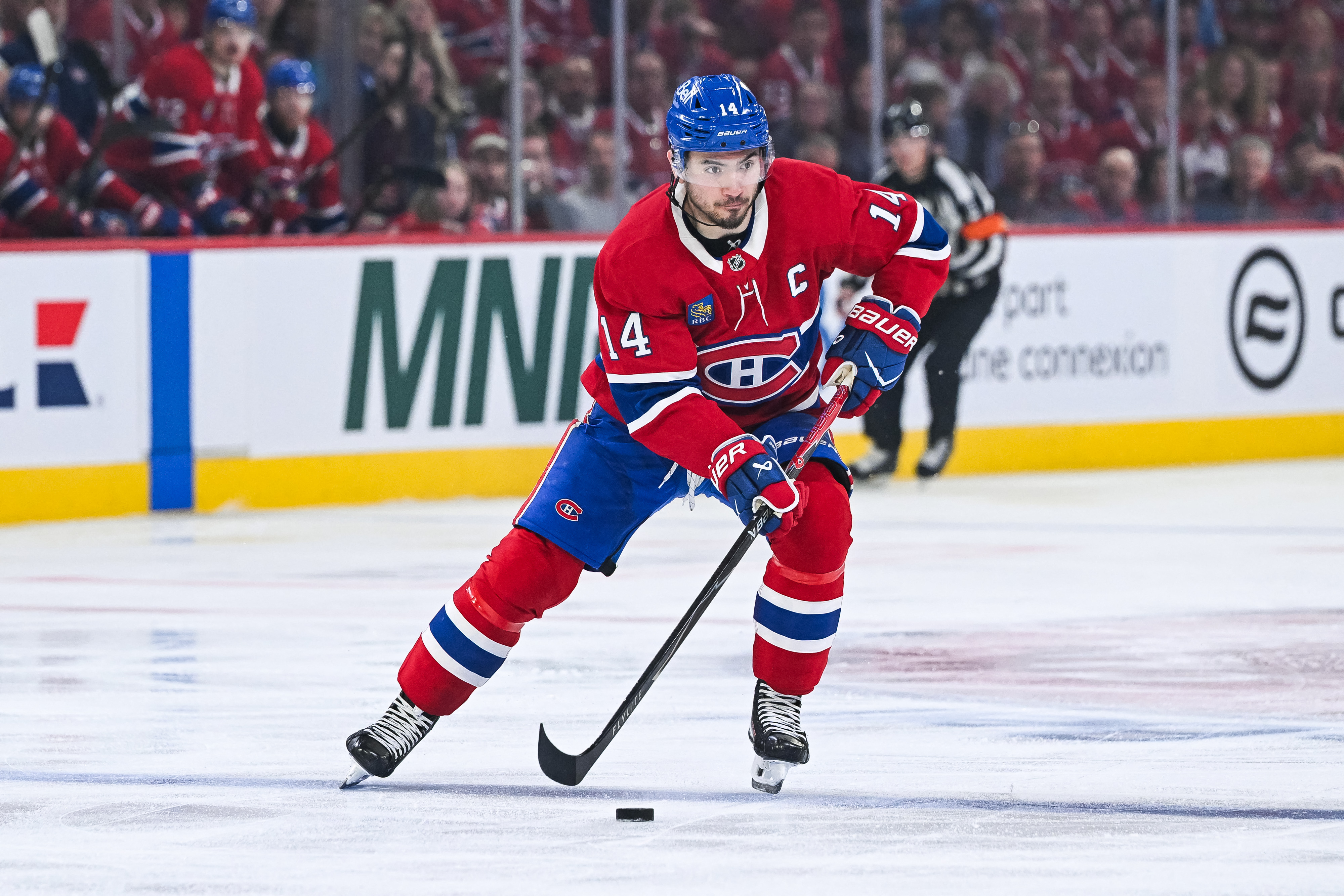 Montreal Canadiens center Nick Suzuki (14) skates with the puck as we provide our NHL anytime goal scorer predictions today.