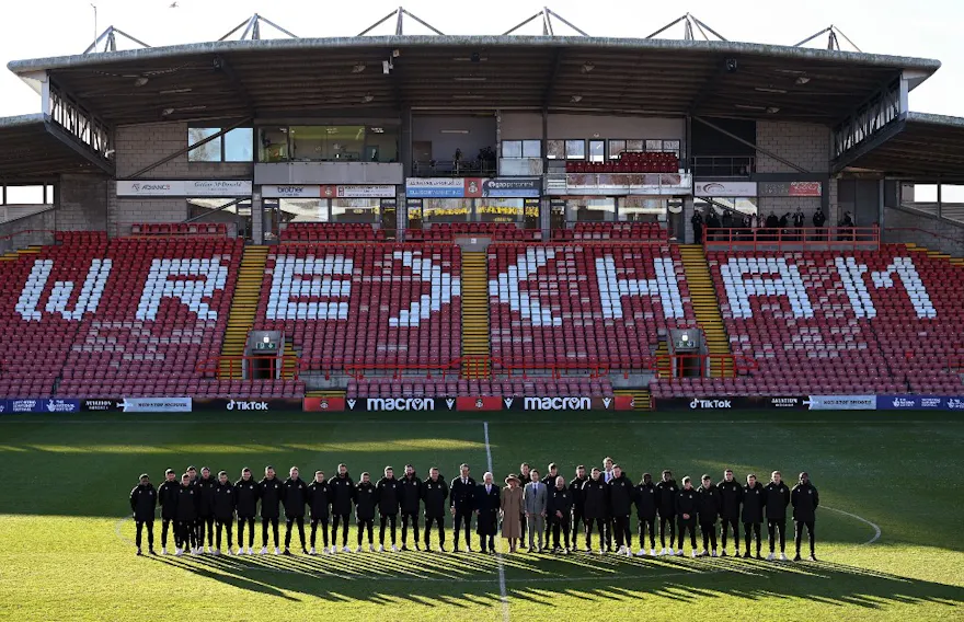 King Charles III stands with Wrexham AFC's Co-Chairmen Ryan Reynolds and Rob McElhenney, and we offer our new U.S. bettors a chance to use our exclusive BetMGM bonus code for Wrexham vs. Wigan.