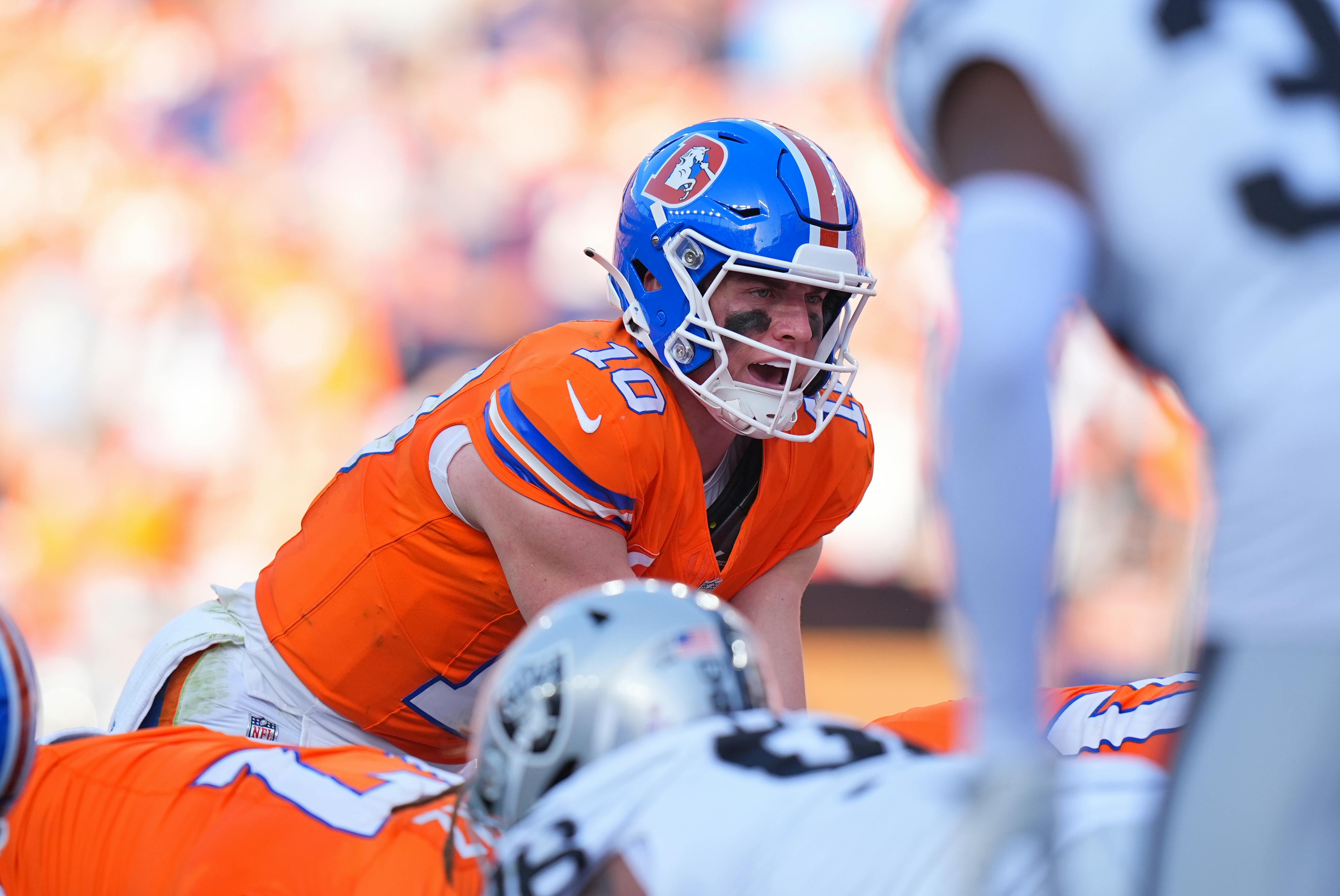 Denver Broncos quarterback Bo Nix prepares to take a snap as we offer our NFL Week 12 odds and predictions.